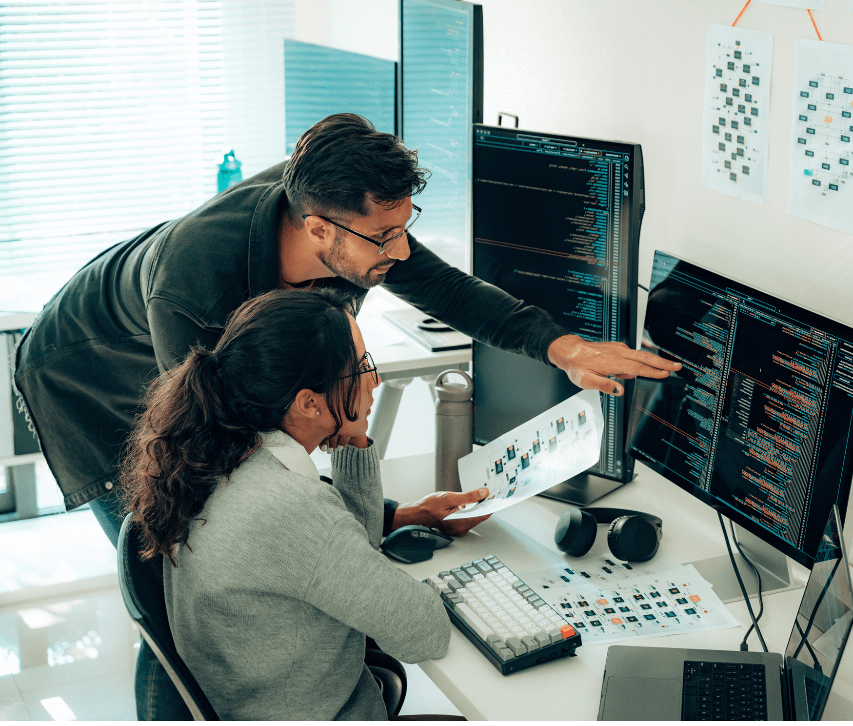 Two colleagues collaborating on computer code.