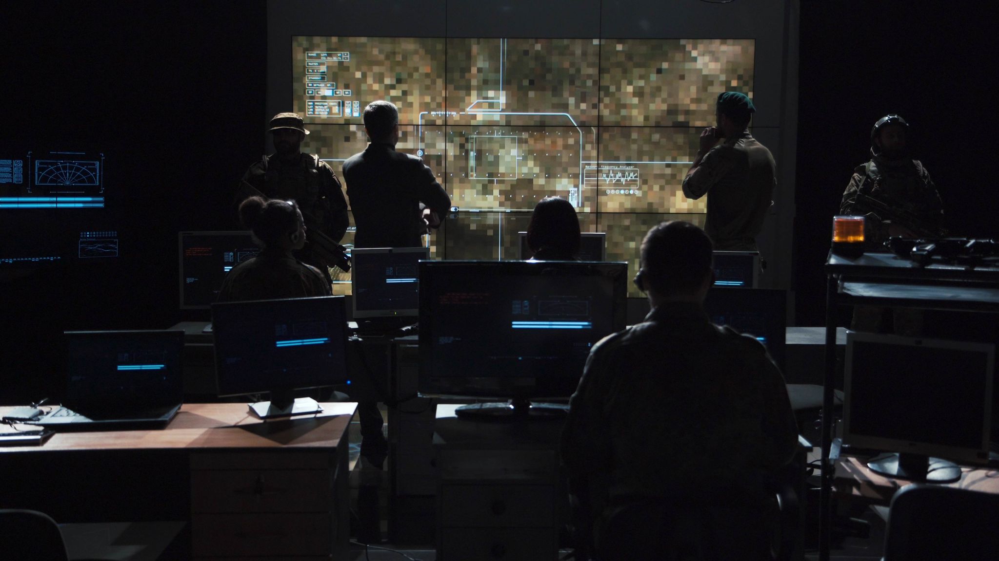 Military personnel in a control room setting.